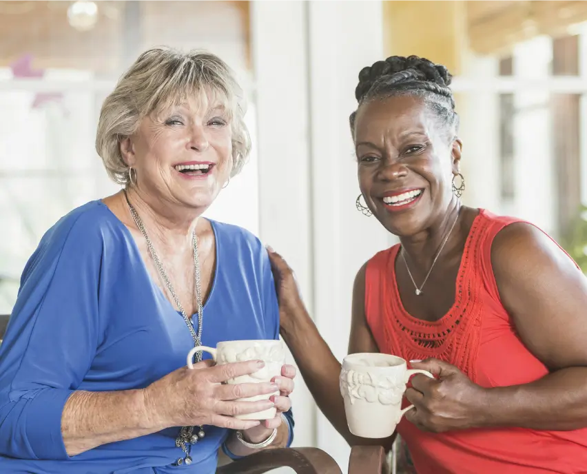 Two senior women drinking coffee together.