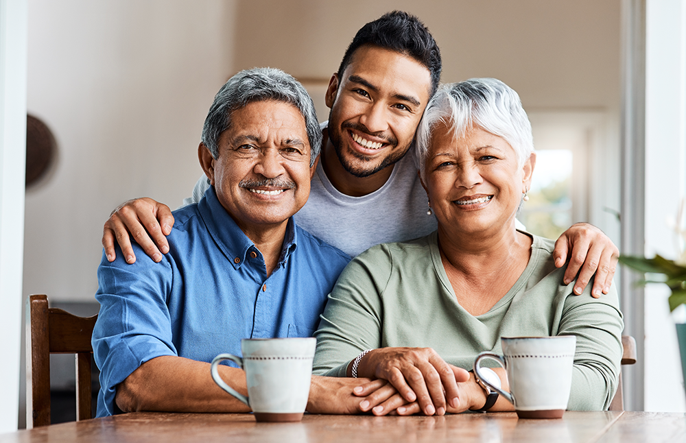 Hispanic man with his arms around his senior mother and father