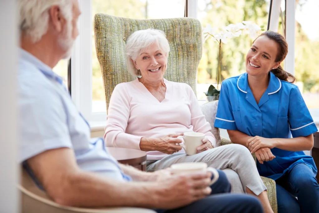 Seniors drinking coffee and talking with caregiver